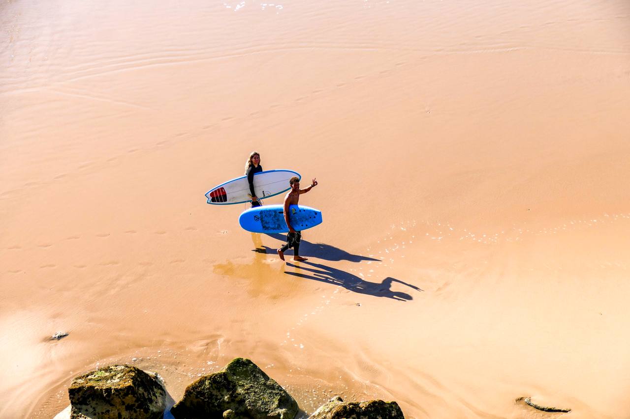 Surfeurs portant leurs planches vers la plage près de Taghazout