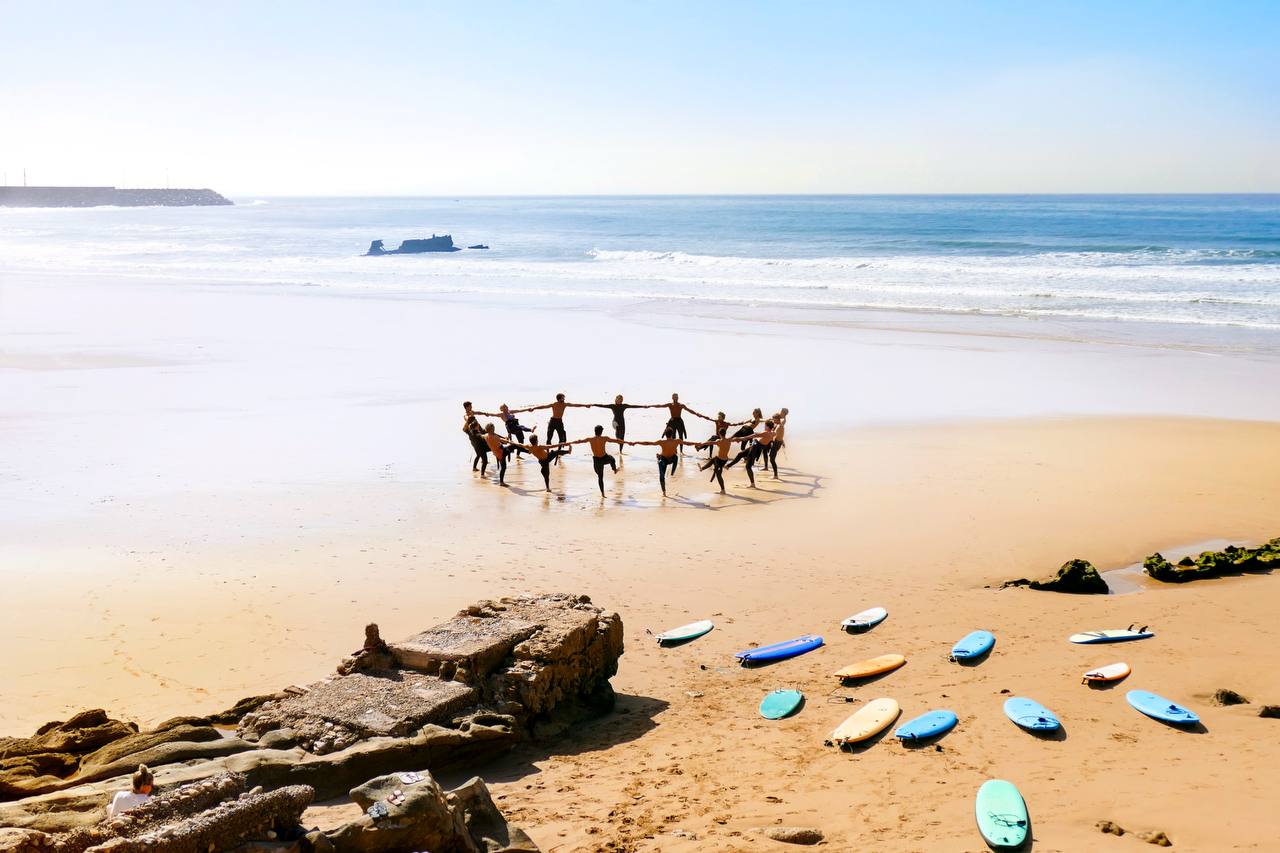 Groupe du surf camp s’échauffant sur la plage avant un cours