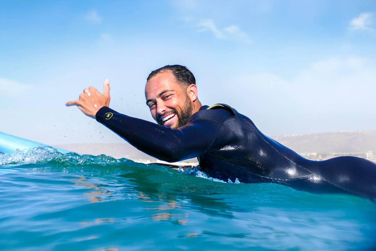 Surfeur souriant dans l’océan pendant une session Surf Treasure Morocco