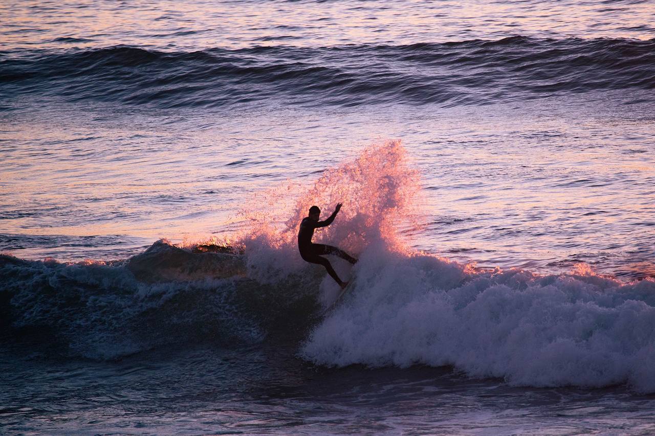 Surfer cutting back at sunset with spray in the air