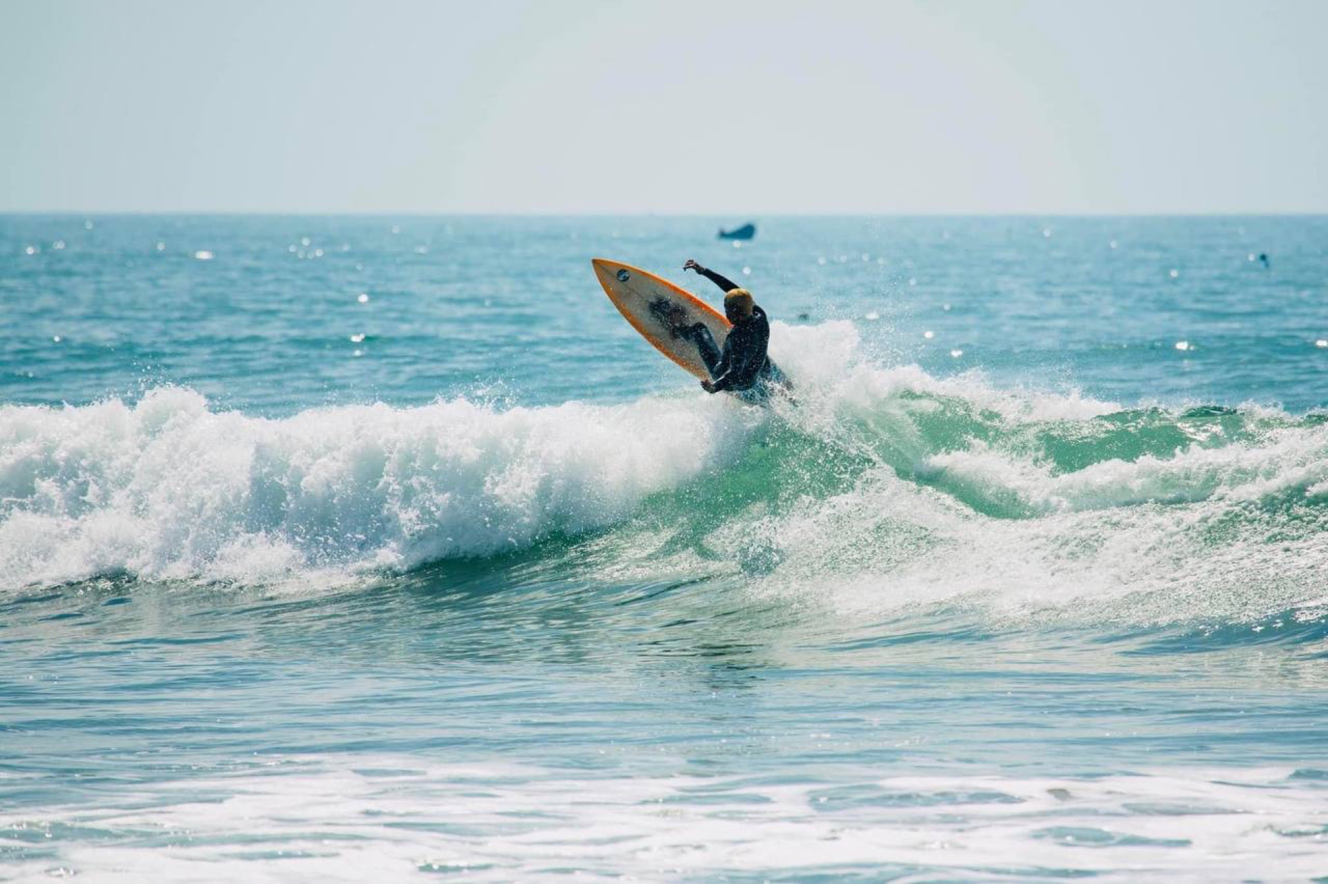 Surfer trimming along a golden section at Banana Point in Aourir